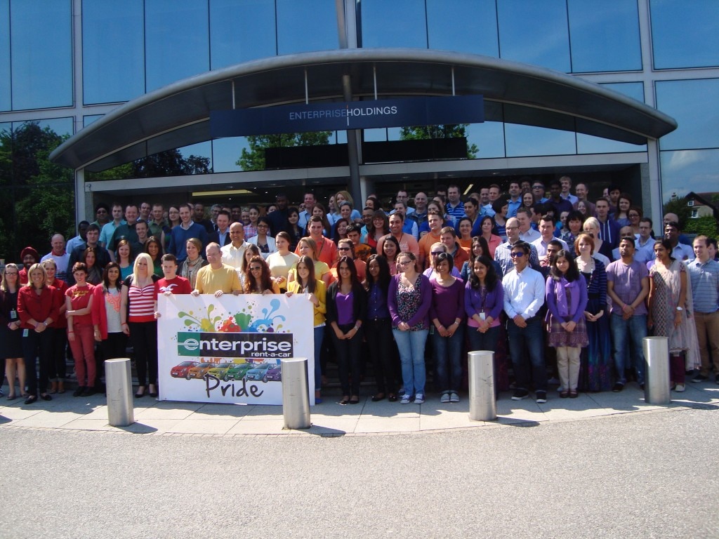 Empleados de Enterprise frente al edificio Enterprise con el banner de Pride